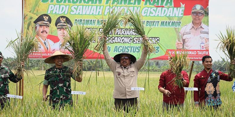 Bupati Kutai Kartanegara Edi Damansyah (memakai kacamaata) sedang mengangkat kedua tangannya memegang hasil panen padi saat panen raya di salah satu wilayah di Kabupaten Kutai Kartanegara beberapa waktu lalu.