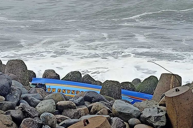 Kondisi perahu nelayan yang pecah teronggok di antara batu pemecah ombak di Pantai Glagah, Kabupaten Kulon Progo, Daerah Istimewa Yogyakarta. Peristiwa perahu nelayan terbalik mengakibatkan satu orang tewas, satu lagi selamat.