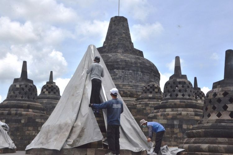 Petugas Balai Konservasi Borobudur sedang memasang terpaulin di stupa Candi Borobudur guna mengantisipasi hujan abu vulkanik Gunung Merapi, Rabu (11/11/2020).