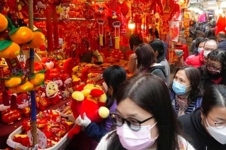 Orang-orang berjalan melewati dekorasi Tahun Baru Imlek di pasar untuk merayakan Tahun Baru Imlek di Hong Kong, Senin (31/1/2022). 