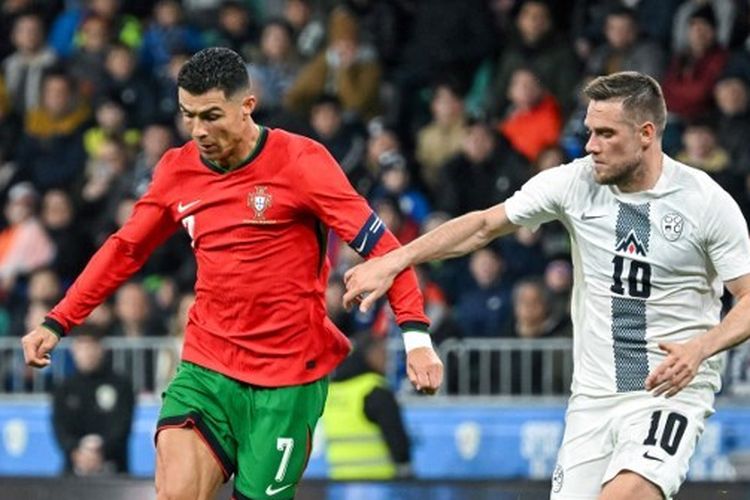 Cristiano Ronaldo berebut bola dengan gelandang Slovenia Timi Elsnik dalam laga persahabatan Slovenia vs Portugal di Stadion Stozice in Ljubljana, Rabu (27/3/2024) dini hari WIB. (Photo by Jure Makovec / AFP)