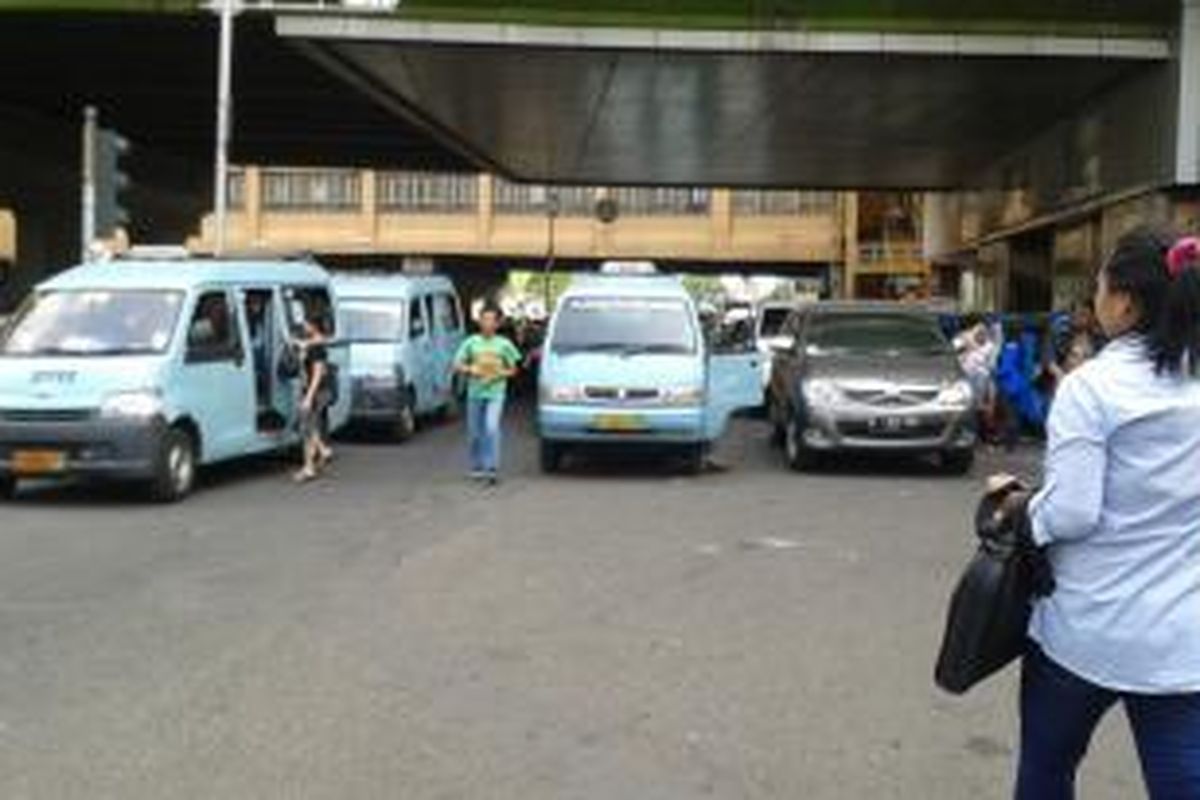 Kondisi jalan jam 14:30 di depan pasar Blok A Tanah Abang, Jakarta Pusat, Selasa (14/10/2014). Mobil angkot yang ngetem menutupi dua lajur di jalan tersebut yang menyebabkan kendaraan pribadi kesulitan untuk lewat.