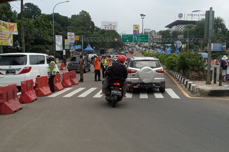 Sejumlah petugas gabungan mengkombinasikan rekayasa lalu lintas berupa ganjil genap dan sistem satu arah atau one way di Jalur Puncak Bogor, Jawa Barat, Minggu (19/9/2021).