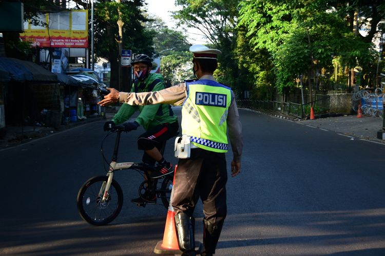 Polisi menghadang para pesepeda untuk diputar balikan ke rumah masing-masing di Jalan Sukajadi, Kota Bandung, Minggu (4/7/2021). Polisi mengimbau para pesepeda untuk tidak bersepeda sementara waktu selama PPKM darurat di Bandung.