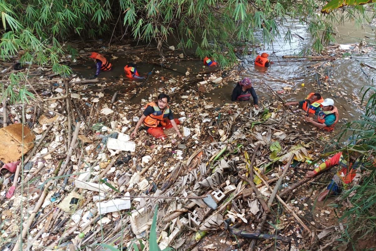 Pasukan Katak Oranye yang diterjunkan untuk membersihkan sampah bambu yang menyumbat aliran sungai Kali Cikeas di Sungai Bendung Koja, Kecamatan Jatiasih, Kota Bekasi, Kamis (26/5/2022).
