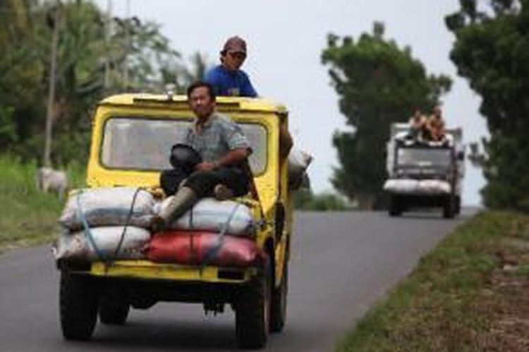 Petani mengangkut kopra untuk dibawa ke pabrik pengolahan kopra di Kecamatan Tenga, Kabupaten Minahasa Selatan, Sulawesi Utara, Selasa (19/8/2014). Harga kopra di kawasan tersebut saat ini berkisar Rp 8.000 per kilogram. 