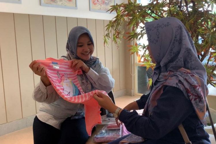 Pemilik brand pakaian anak lokal Chubbydut, Lutfia Nurul Aini menunjukkan produknya kepada calon pelanggan, Selasa (25/10/2022).