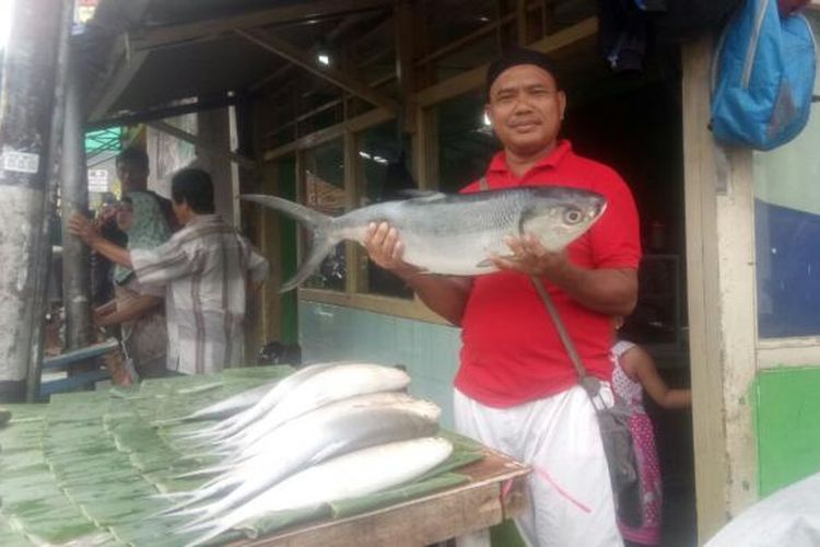Udin (45), salah satu pedagang sedang memegang ikan bandeng dengan bobot 8 kilogram di Rawa Belong, Jakarta Barat. Pasar ini hanya ada jelang imlek. Gambar diambil Rabu (25/1/2017).