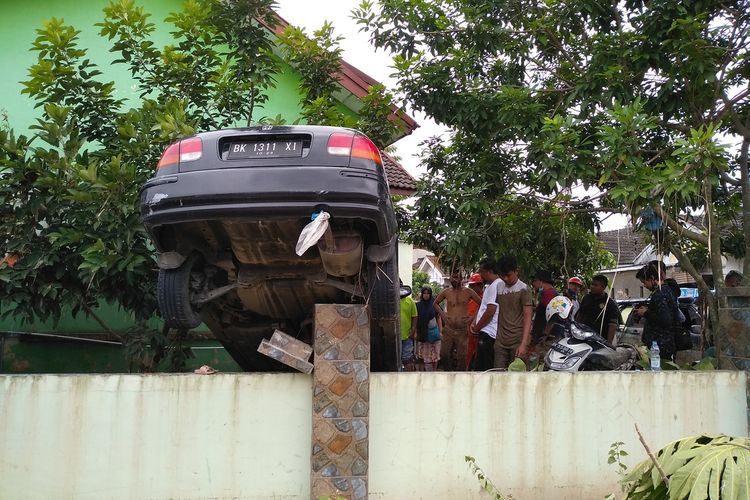 Posisi mobil milik Defri Solihin tersangkut di pagar. Pohon rambutan menghalanginya saat terjadi banjir di perumahan De Flamboyan di Kelurahan Tanjung Selamat, Kecamatan Medan Tuntungan pada Kamis malam hingga Jumat dini hari (4/12/2020).