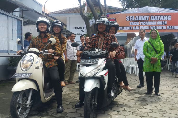 NAIK MOTOR --Dosen Fakultas Ekonomi Universitas Indonesia, Harriyadin Mahardika bersama pasangannya, Arief Rachman menumpang sepeda motor saat mendaftarkan diri  sebagai bakal calon walikota dan wakil walikota Pilkada Kota Madiun di Kantor KPU setempat, Senin (7/1/2018).