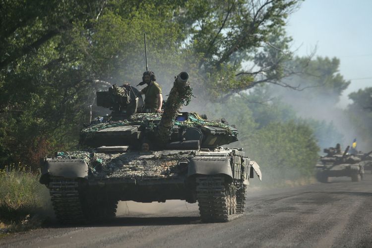 Tentara Ukraina berdiri di atas tank yang melaju di Donbass, Ukraina timur, 21 Juni 2022. Perang Rusia vs Ukraina terkini berfokus di kota Lysychansk dekat Severodonetsk yang dibombardir Rusia selama beberapa minggu terakhir.