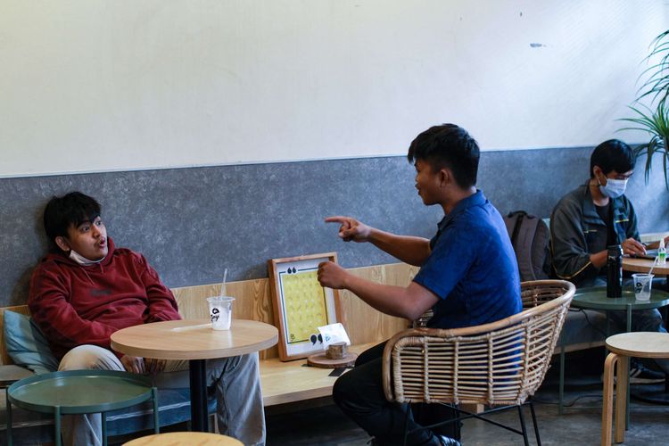 Pelanggan Kafe Sunyi House of Coffee and Hope, Jakarta berkomunikasi dengan bahasa isyarat, Rabu (10/2/2021). Semua pekerja yang ada di Kafe Sunyi ini adalah orang  orang penyandang disabilitas.