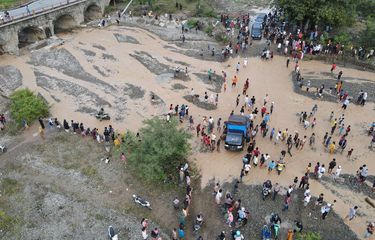 Foto udara pengendara melintasi sungai akibat jembatan amblas dan tidak dapat dilalui di Kelurahan Buluri di Palu, Sulawesi Tengah, Jumat (7/4/2023). Jembatan pada jalur penghubung Kota Palu dan Donggala hingga ke Sulawesi Barat dan Sulawesi Selatan serta menjadi salah satu jalur utama bagi pemudik tersebut terputus sehingga pengguna jalan terpaksa melintasi sungai.