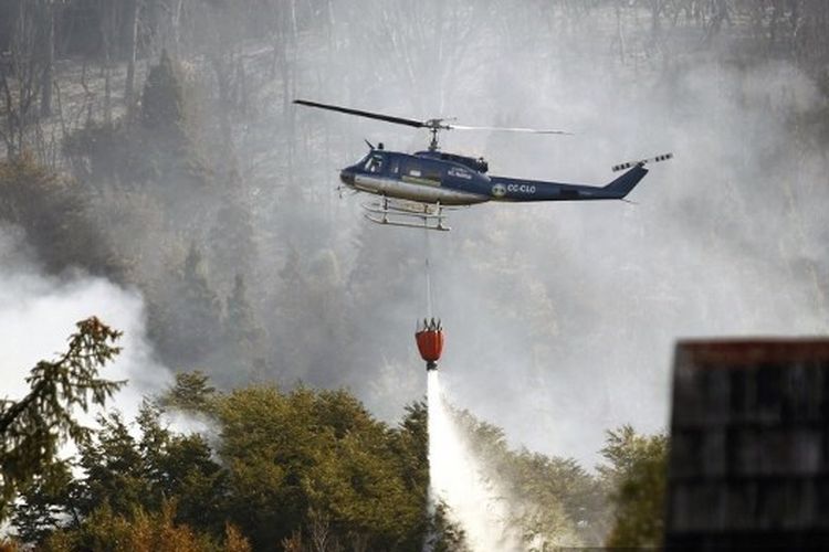 Helikopter Chili bekerja di hutan yang terbakar di Taman Nasional Los Alerces dekat Desa Futalaufquen di provinsi Patagonian Chubut, Argentina, sekitar 1.900 Km barat daya Buenos Aires, pada 25 Maret 2015. 