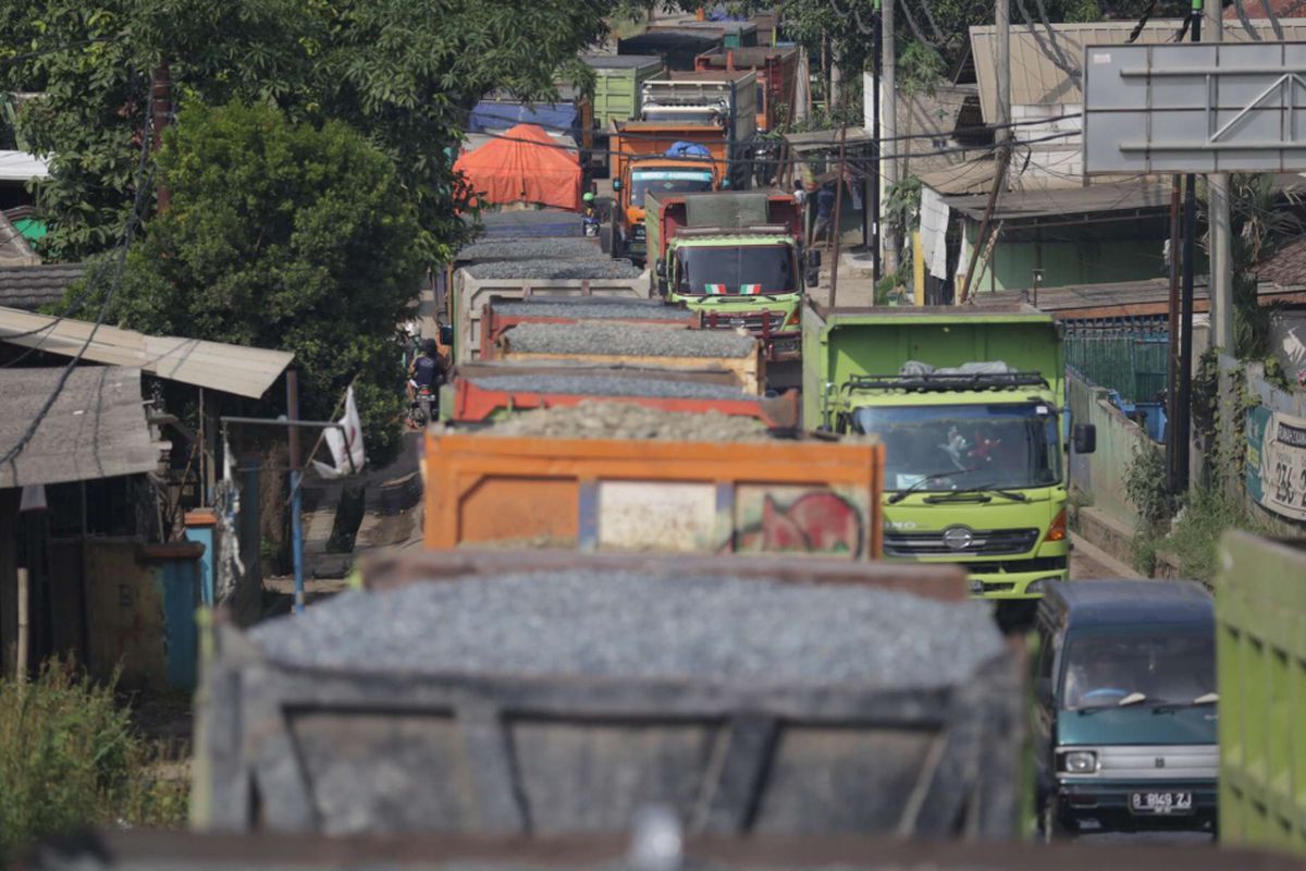 Ratusan mobil truk berhenti menunggu selesainya pembatasan jam operasional truk di jalan raya Parung Panjang menuju Legok, Kabupaten Tangerang, Banten, Kamis (10/01/2019). Pemerintah Kabupaten Tangerang membatasi jam operasional kendaraan jenis truk golongan 2 hingga truk golongan 5 yang membawa muatan material tanah dan pasir. Jenis-jenis kendaraan tersebut baru dapat melintas pukul 22.00-05.00 WIB.