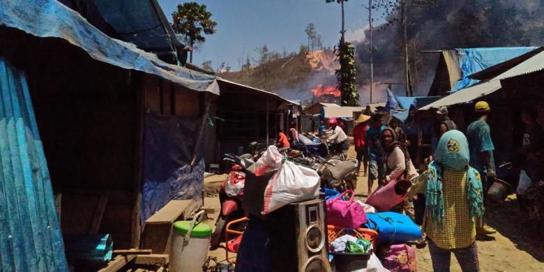Satu keluarga penambang bersama seorang bocah meninggalkan kawasan tambang Gunung Botak Minggu (15/11/2015). setelah tenda tempat tinggal mereka di kawasan itu dibakar aparat