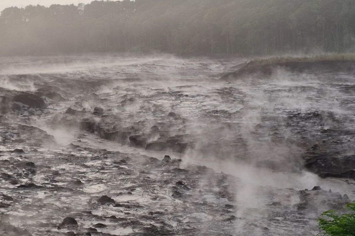 Tumpukan material vulkanik Gunung Semeru di bawah Jembatan Gladak Perak mengeluarkan asap panas