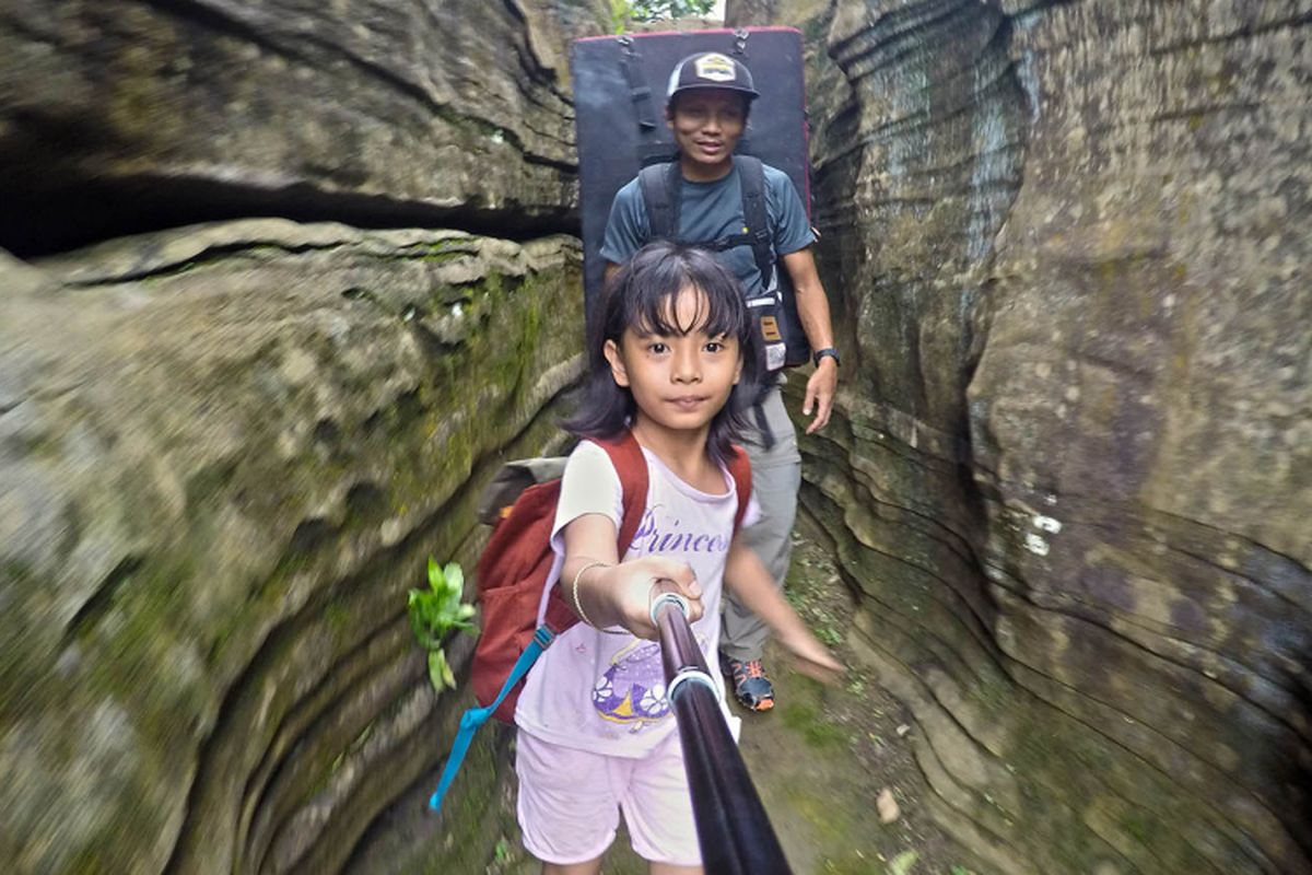 Bening, 8 tahun, trekking melintasi tebing karst di kawasan Gua Harunggang, di Babakan Madang, Kabupaten Bogor, Minggu (25/2/2018).