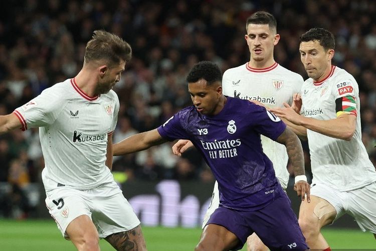 Penyerang Real Madrid Rodrygo (tengah) berebut bola dengan bek Athletic Bilbao Yeray Alvarez dan Oscar De Marcos selama pertandingan La Liga Spanyol antara Real Madrid vs Athletic Bilbao pada 31 Maret 2024. (Foto oleh Pierre-Philippe MARCOU / AFP)