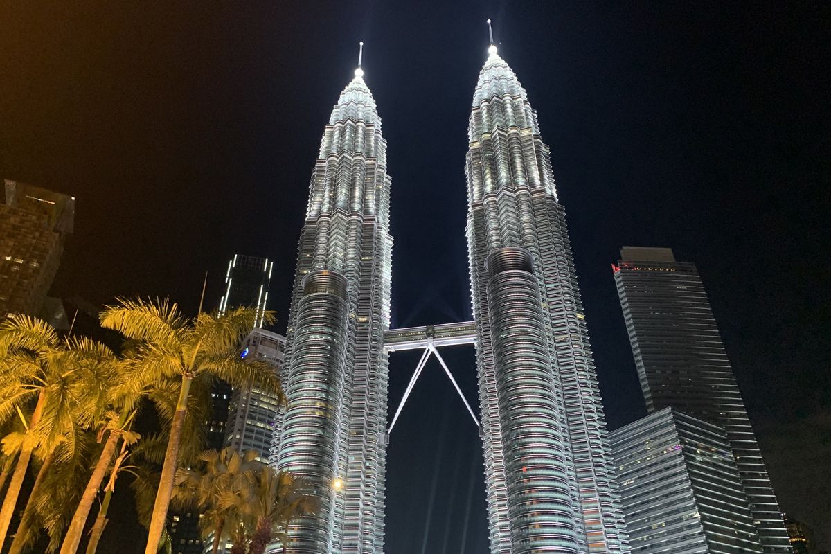 Pemandangan Menara Kembar Petronas (Petronas Twin Towers) dengan gedung-gedung lainnya di Kuala Lumpur City Centre (KLCC), Malaysia, pada malam hari, Kamis (17/4/2025). Foto ini diambil dari seberang Jembatan Saloma.