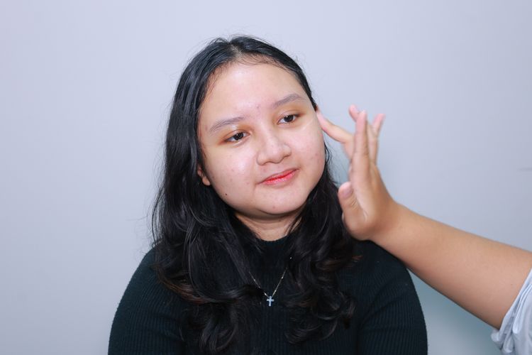 Model memakai sunscreen khusus kulit berminyak.