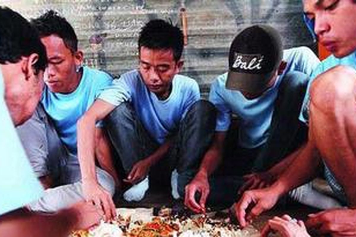 Sejumlah buruh borongan menikmati makan siang mereka secara bersama di kontrakan buruh di kawasan Kalideres, Jakarta Barat, Selasa (7/2/2012). Makan bersama dilakukan untuk menekan biaya hidup mereka. Sebagai buruh borongan pabrik sandal, dalam satu bulan mereka menerima upah maksimal Rp 1,2 juta.