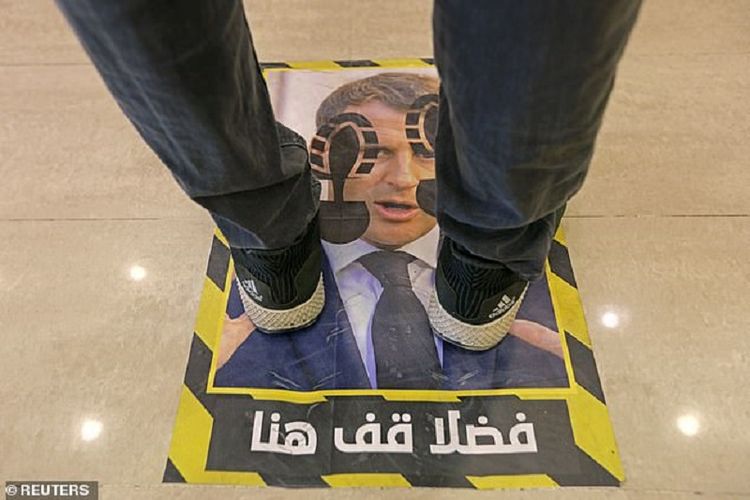 Sebuah toko di Tripoli, Libya, memasang wajah Presiden Perancis Emmanuel Macron sebagai alas lantai guna panduan pembatasan sosial. Langkah itu mereka lakukan sebagai bentuk protes atas keputusan Macron yang membela penayangan kartun Nabi Muhammad.