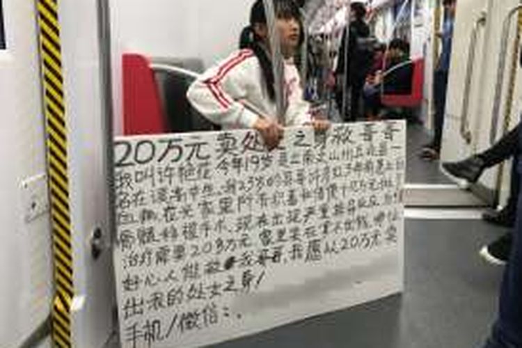 Xu (19), membawa papan berisi tulisan soal niatnya menjual keperawanan untuk mencari biaya pengobatan untuk kakaknya yang sakit leukemia,