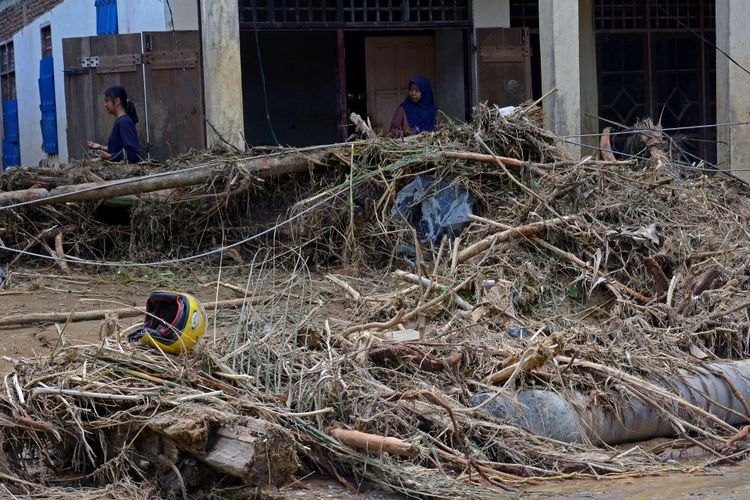 Warga melintas di depan rumah yang terdampak banjir bandang di Desa Kaili, Kecamatan Suli Barat, Kabupaten Luwu, Sulawesi Selatan, Minggu (5/5/2024). Banjir bandang akibat luapan sungai Suli yang terjadi pada Jumat (3/5) lalu menyebabkan 42 unit rumah hanyut dan 50 unit rumah rusak berat di tiga desa di Kecamatan Suli Barat. ANTARA FOTO/Hasrul Said/YU/nym.