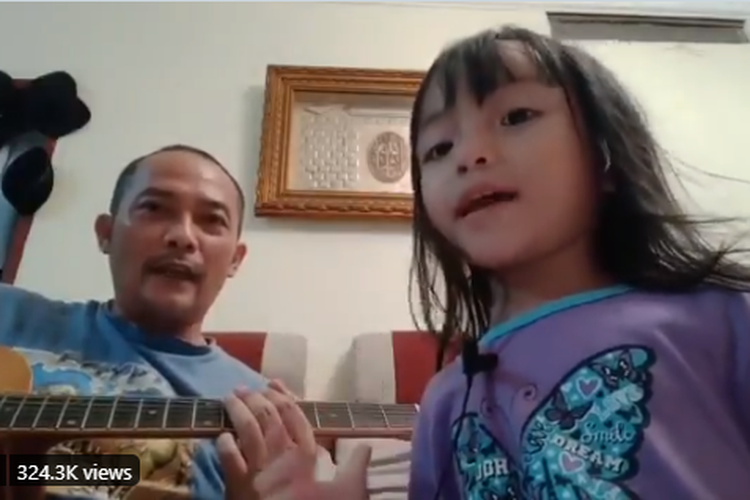 Seorang anak bersama ayahnya menyanyikan lagu Killing In The Name milik RATM.