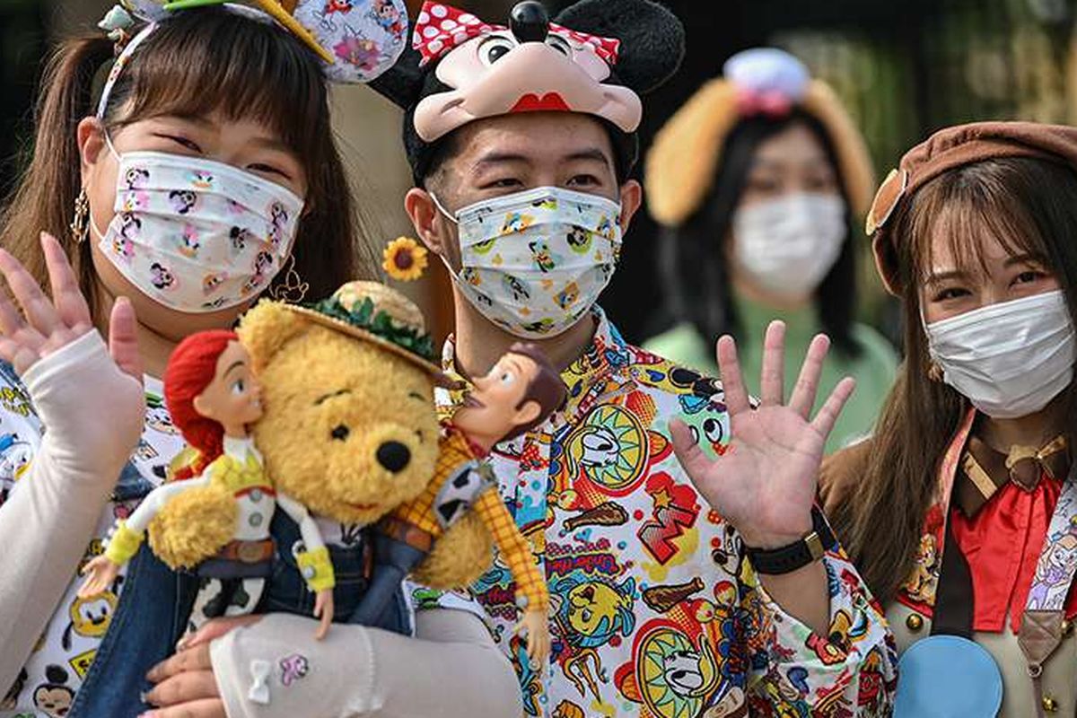 Pengunjung mengenakan masker saat mendatangi taman hiburan Disneyland, Shanghai, China, yang baru dibuka kembali, Senin (11/5/2020). Shanghai Disneyland resmi kembali dibuka setelah ditutup selama 4 bulan akibat pandemi virus corona.