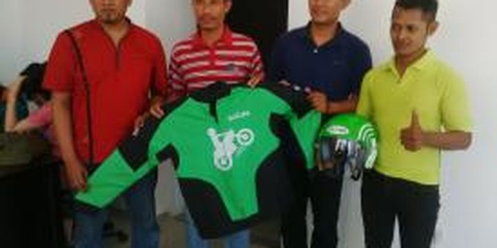 Mantan pemain timnas sepak bola Indonesia Anang Ma'ruf (kedua dari kiri) menerima atribut Go-Jek setelah resmi bergabung dengan perusahaan aplikasi pemesan layanan ojek itu, Jumat (4/9/2015).