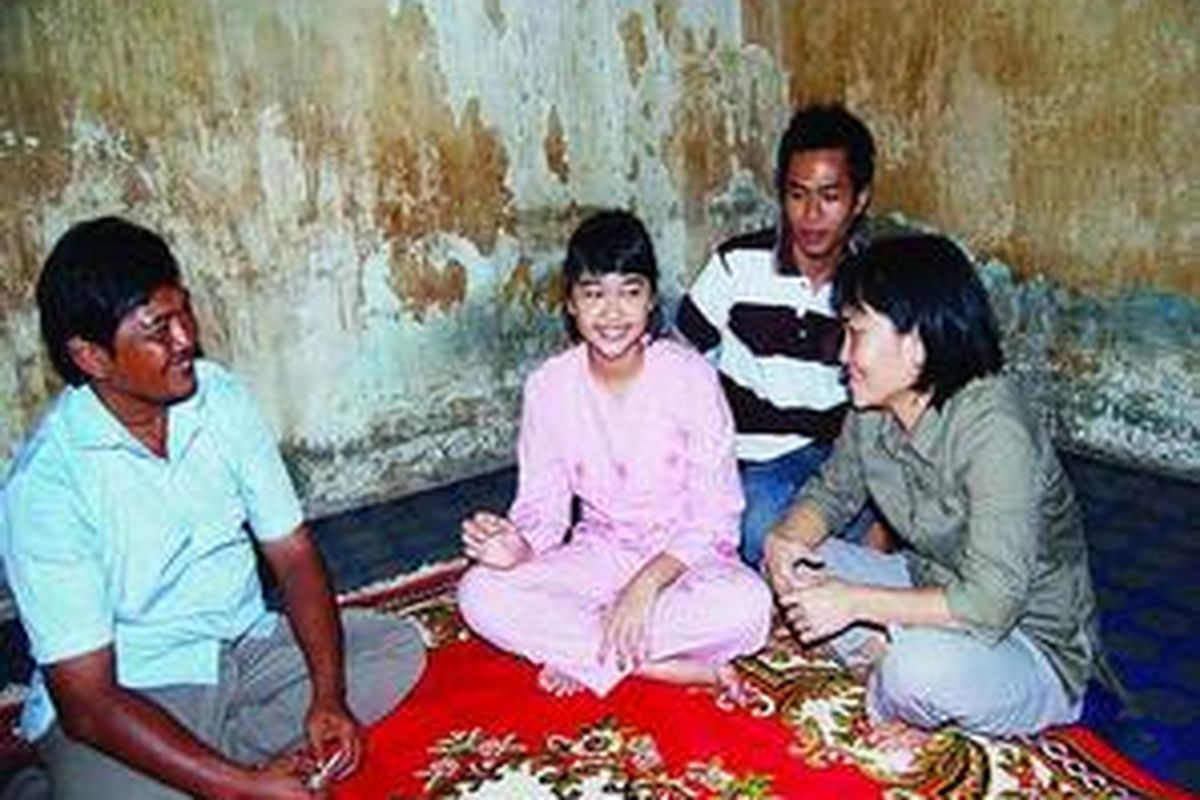 Lovely Octaviolendy (15, kedua dari kiri) berbincang dengan kedua orangtuanya di ruang tamu rumah kontrakannya, Kamis (23/7). Meski berasal dari keluarga tak mampu karena kedua orangtuanya berprofesi sebagai penjual jeruk keliling, Lovely berhasil lolos ujian masuk ke SMAN Internasional Sumatera Selatan yang distandardisasi oleh Cambridge School karena kecerdasan akademiknya.