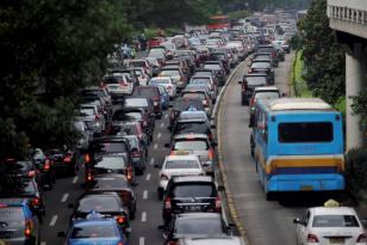 Kendaraan pribadi melintas jalur bus Transjakarta saat terjadi kemacetan di Jalan Sudirman, Jakarta, Senin (26/11/2012).  Kemacetan parah yang terjadi membuat polisi melonggarkan jalur bus transjakarta dilewati kendaraan lain.