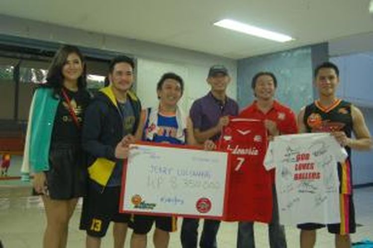 mantan pebasket Satya Wacana LBC Angsapura Salatiga (sekarang Satya Wacana Metro LBC Bandung), Jerry Lolowang (tengah, kemeja ungu) menerima jersey serta sejumlah uang hasil pertandingan eksibisi antara timnas basket putri melawan Happy Ballers yang digagas oleh Augie Fantinus (ketiga dari kiri), di Hall Basket Senayan, Jakarta, Rabu (27/11/2013). 