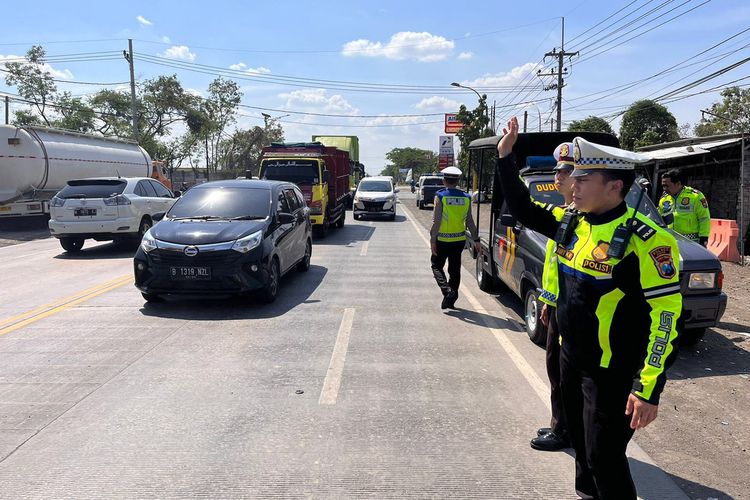 Petugas kepolisian saat olah TKP dan mengatur arus lalu lintas usai kecelakaan di Desa Tebaloan, Kecamatan Duduksampeyan, Gresik, Jawa Timur, Rabu (22/11/2023).
