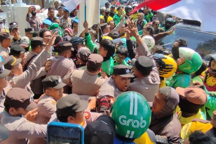 Sejumlah Ojol terlibat saling dorong bersama petugas kepolisian di depan gerbang Kantor Balaikota Cirebon, Rabu (9/8/2023). Ojek Online ini menuntut uang Bantuan Langsung Tunai (BLT) 2022, segera dicairkan.