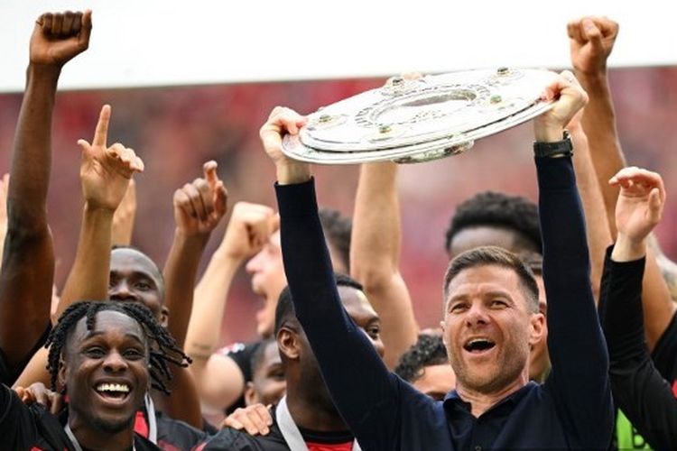 Pelatih Bayer Leverkusen, Xabi Alonso, mengangkat gelar trofi juara Bundesliga setelah timnya menang 2-1 atas  FC Augsburg di BayArena, Sabtu (18/5/2024). 