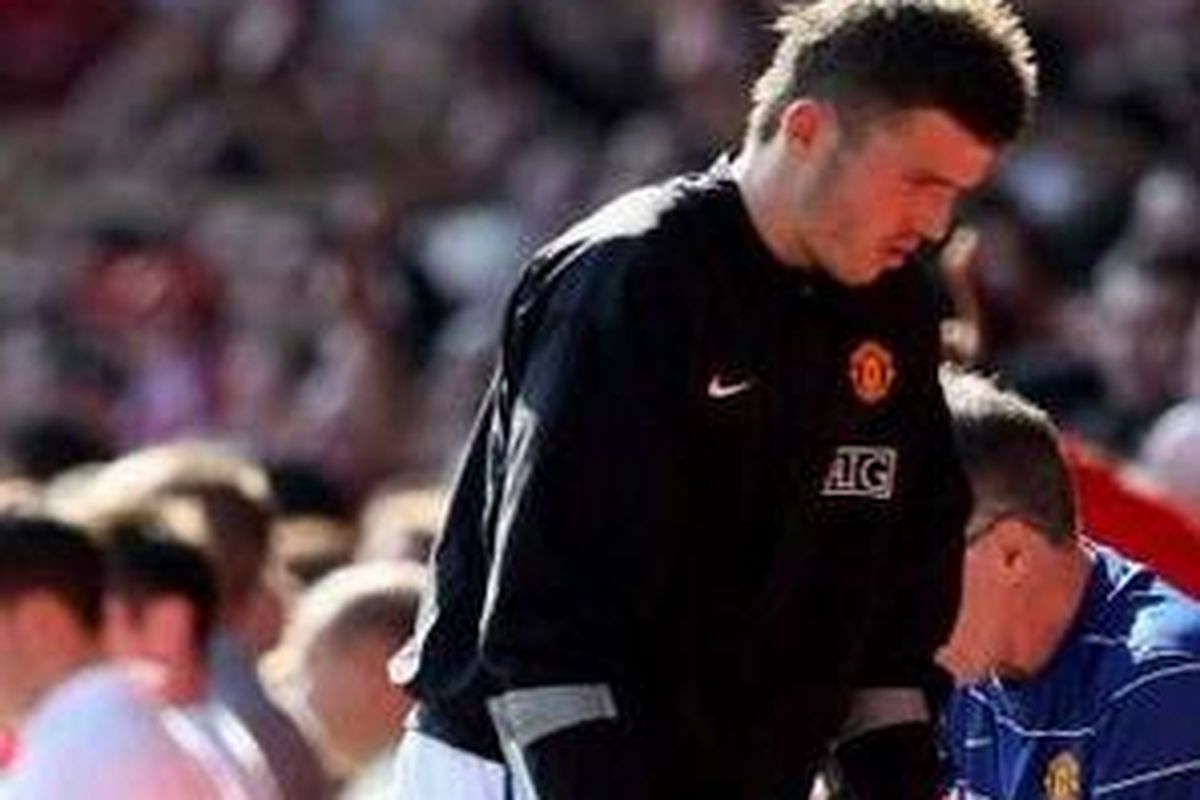 Michael Carrick berjalan menggunakan tongkat penyangga setelah mengalami cedera kaki kanan saat lawan Liverpool, Sabtu (13/9).