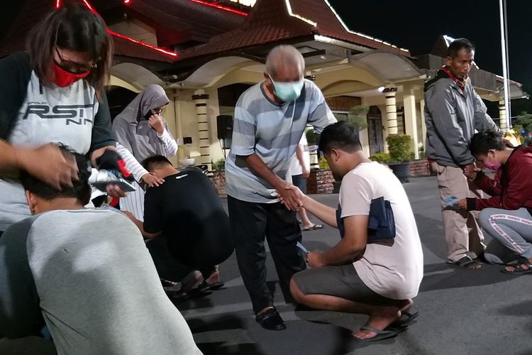 MINTA MAAF—Warga yang terciduk operasi balap liar ditengah pandemic covid-19 bersimpuh meminta maaf kepada orang tua sebelum dipulangkan. Mereka dikenakan tilang dan wajib lapor seminggu dua kali di Polres Madiun Kota.