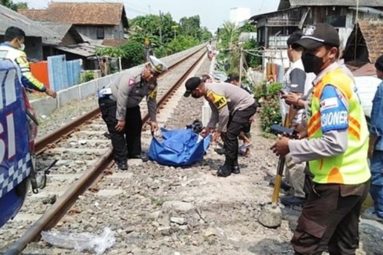 Petugas kepolisian saat mengevakuasi korban tertabrak kereta di Citangkil, Kota Cilegon, Banten pagi tadi