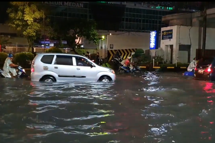 Sejumlah pengendara berusaha menerobos genangan air di Jalan Stasiun, Medan. 