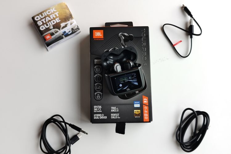 TWS JBL Tour Pro 3 memiliki kemasan dengan warna hitam yang dominan. Tertulis cukup banyak keterangan di kemasan tersebut, seperti keterangan fitur dan spesifikasi. Isi kemasannya cukup lengkap mulai dari kabel charger, eartips cadangan, hingga kabel AUX. 