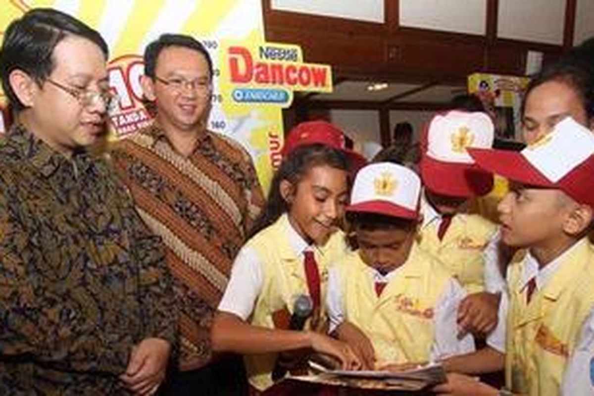 Direktur Dairy Business PT Nestle Indonesia Jason Avancena (kiri) bersama Wakil Gubernur DKI Jakarta Basuki T Purnama (dua kiri) mengawasi finalis Dokter Kecil Mahir Gizi 2012 asal Papua yang sedang mempraktikan pendataan ukuran tinggi dan berat badan, di Balai Kota Jakarta, Senin (25/2/2013). Dua puluh sembilan tim pemenang disambut Wagub DKI hari ini. Kegiatan tersebut merupakan bagian dari program Caravan Gizi Nestle Dancow bekerjasama dengan Perhimpunan Dokter Gizi Medik Indonesia dan Kemendikbud RI.