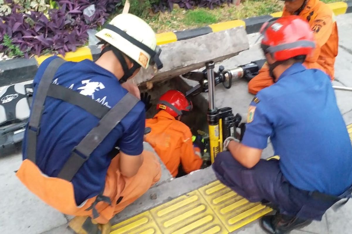 Damkar Bantu Evakuasi Handphone Pengemudi Ojek Online yang Tercebur Ke Selokan di Jalan Jatinegara Barat, Jatinegara, Jakarta Timur, Jumat (23/8/2019).