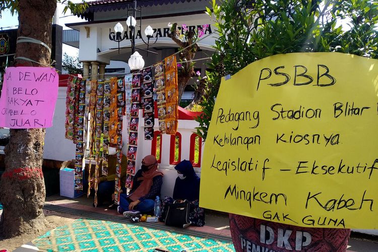 Belasan pedang penyewa kios di Stadion Supriyadi Kota Blitar memindahkan barang dagangan mereka di depan Kantor DPRD Kota Blitar dalam aksi unjuk rasa, Rabu (30/6/2021)