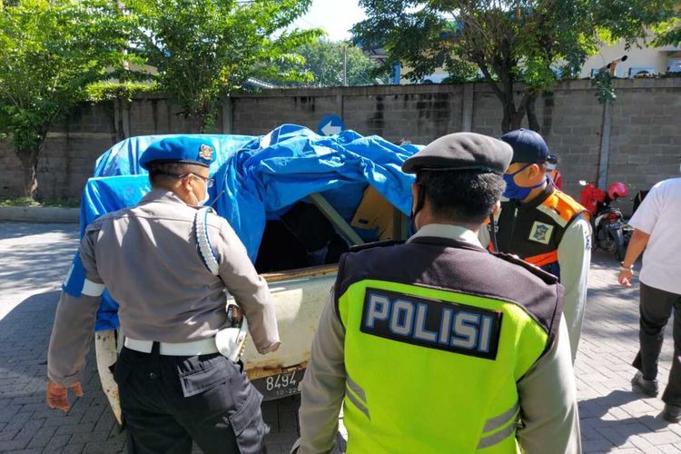 Sebuah pikap Isuzu Phanter berwarna putih nomor kendaraan N 8494 TI diberhentikan petugas gabungan dari kepolisian, TNI, dan Pemkot Surabaya, karena terdapat empat penumpang di balik bak belakang pikap yang tertutup terpal, Selasa (28/4/2020).