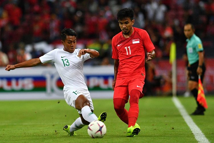 Pemain timnas Indonesia Febri Hariyadi (kiri) mencoba merebut bola dari pemain timnas Singapura Muhammad Yasir Hanapi dalam penyisihan grub B Piala AFF 2018 di Stadion Nasional Singapura, Jumat (9/11/2018).  