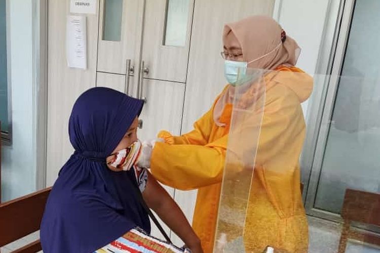 Seorang pedagang pasar menjalani vaksinasi Covid-19 di salah satu puskesmas di Kota Tegal, Rabu (24/3/2021) (Istimewa)