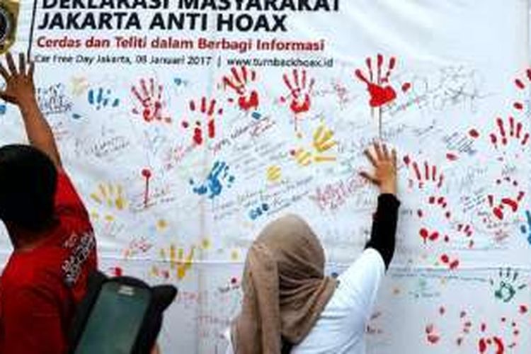 Warga membubuhkan cap tangan saat sosialisasi dan deklarasi Masyarakat Indonesia Anti Hoax di Jakarta, Minggu (8/1). Deklarasi yang juga dilakukan di lima kota lain di Indonesia itu bertujuan membersihkan media sosial dari berita bohong alias hoax. 